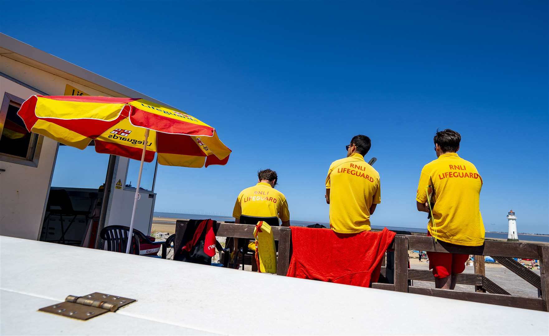 Lifeguards watch sunbathers on New Brighton Beach, Wirral (Peter Byrne/PA)