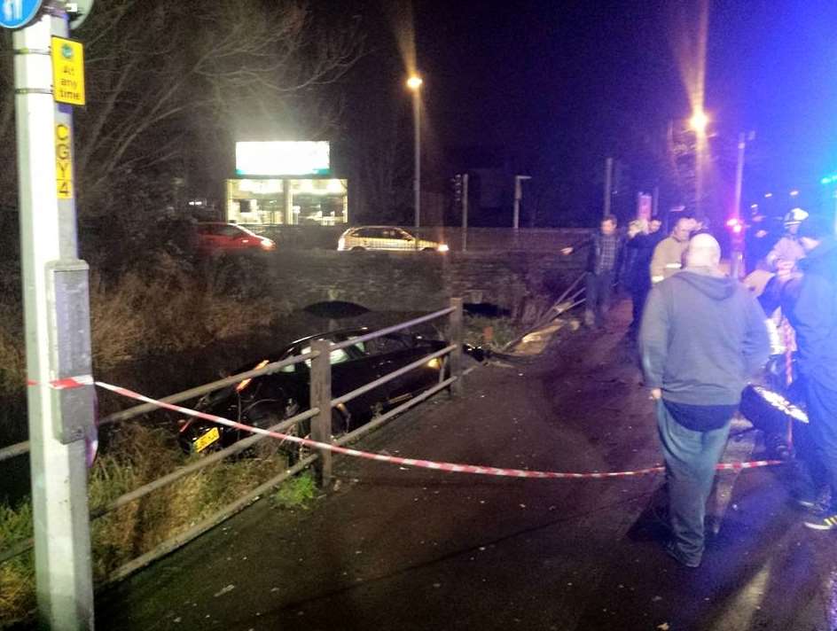 Crowds gathered to see the car on its side in the river. Picture: Luke Jordan