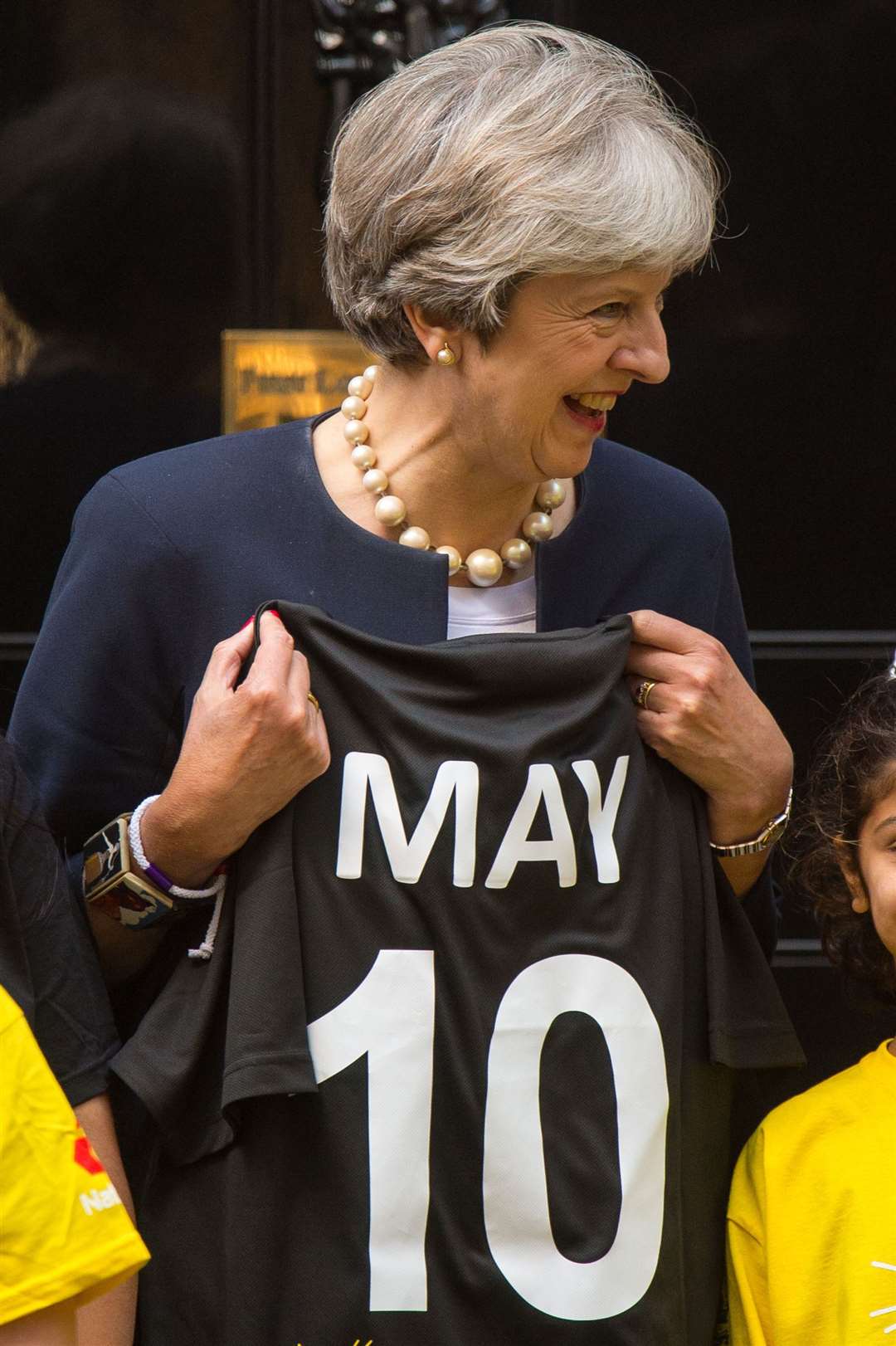 Former prime minister Theresa May is presented with a cricket shirt at a game of street cricket on Downing Street (Dominic Lipinski/PA)