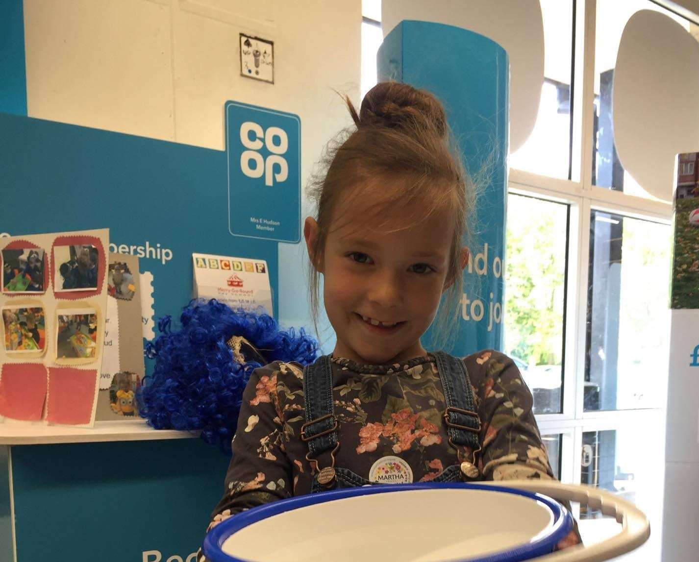 Lila Disney, 7, of Sandwich Carnival Court collecting change for Martha Trust at the town's Co-operative