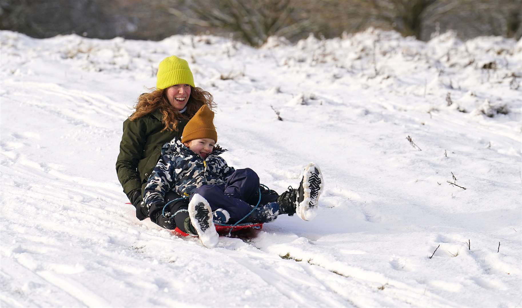 Liz and son Henry sledging on the snow in Tatton Park, Knutsford, Cheshire (Martin Rickett/PA)