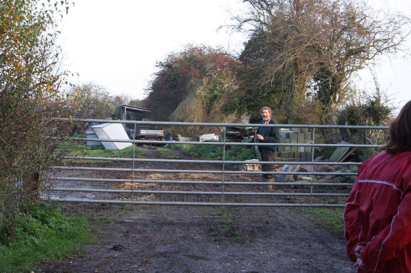 Farmer Craig Sargent watches the protest from the gate of his farm in Halstead