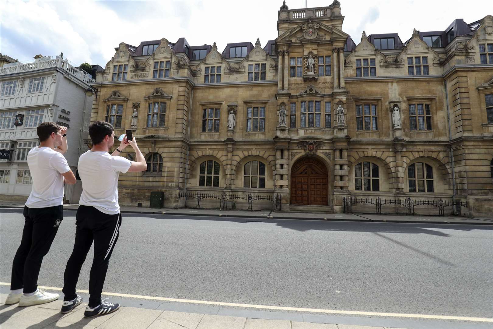 Passers-by photograph the Rhodes statue at Oriel College (Steve Parsons/PA)