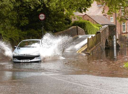 Firefighters save five people from roof of car stuck in flooded ford in ...