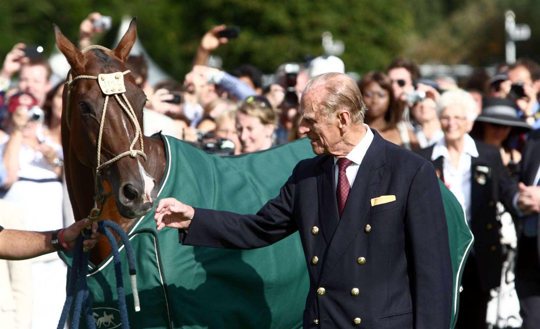 The Duke of Edinburgh admires a horse at the Cartier International Polo event held at Guards Polo in Windsor, Berkshire.