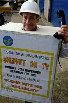 Tim Bell, club member, dressed as a plug, to "plug" the club's need for votes