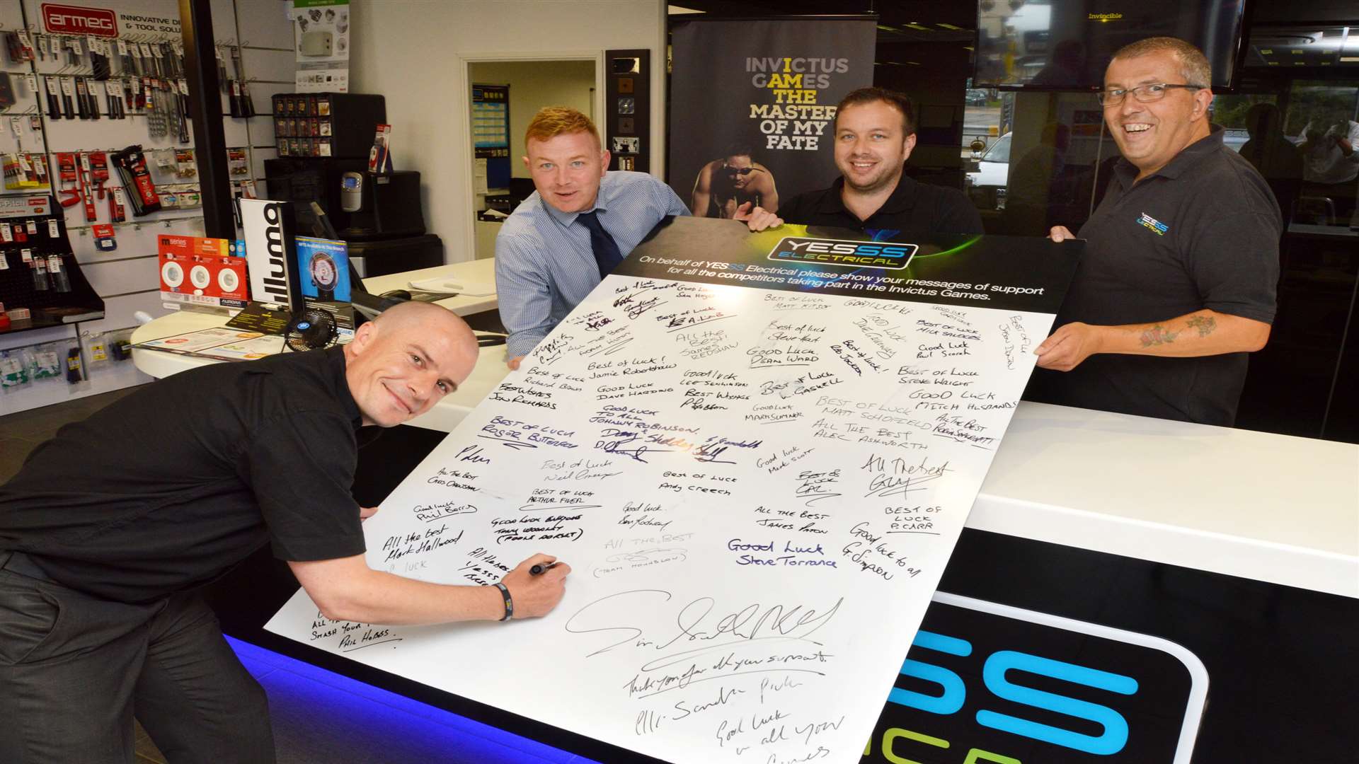 Members of staff at the Yesss electrical branch in Tunbridge Wells sign the giant good luck card
