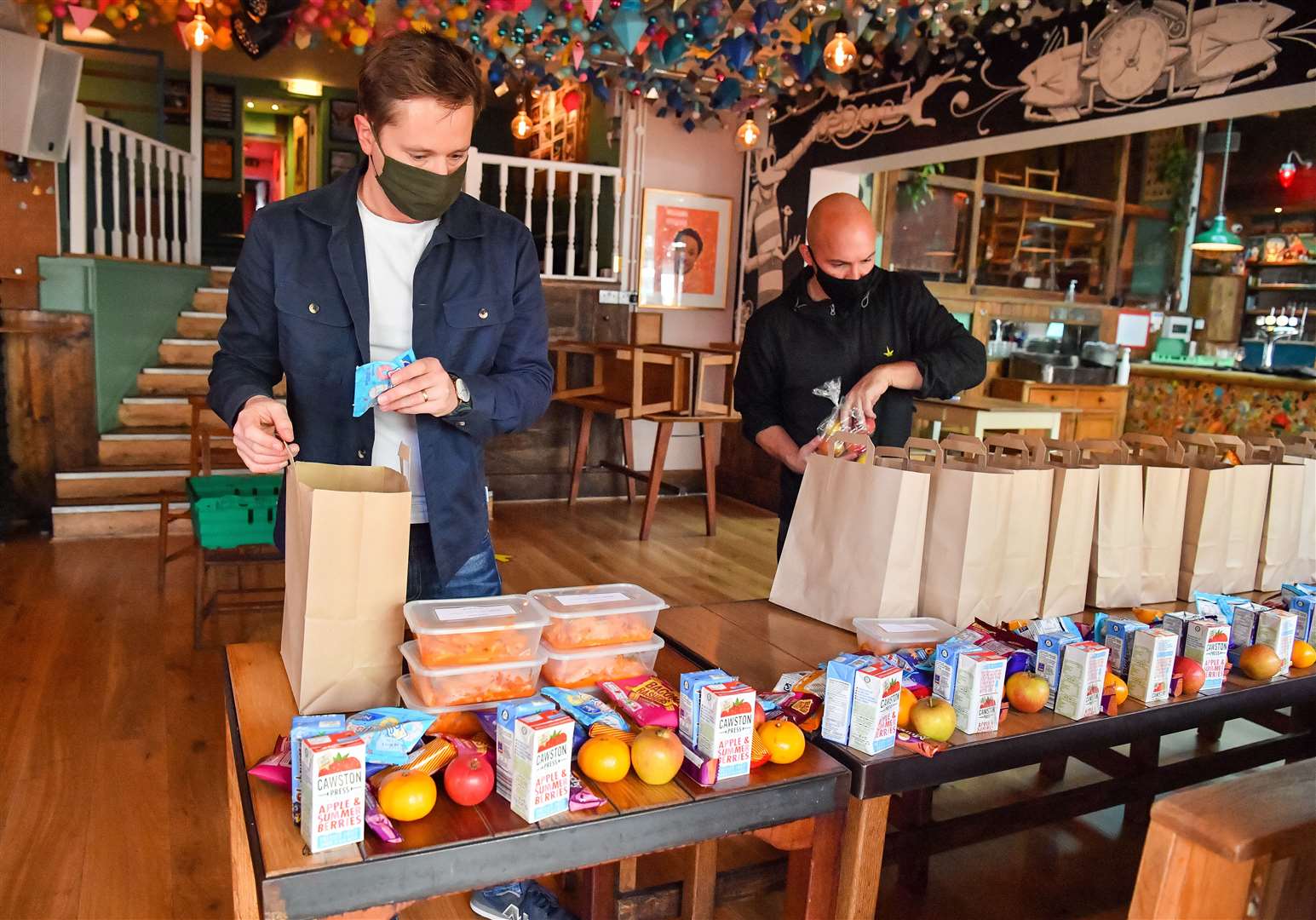 Andy Hope-Johnstone (left) and James Koch prepare free packed lunch bags for delivery at the Gallimaufry pub in Bristol (Ben Birchall/PA)