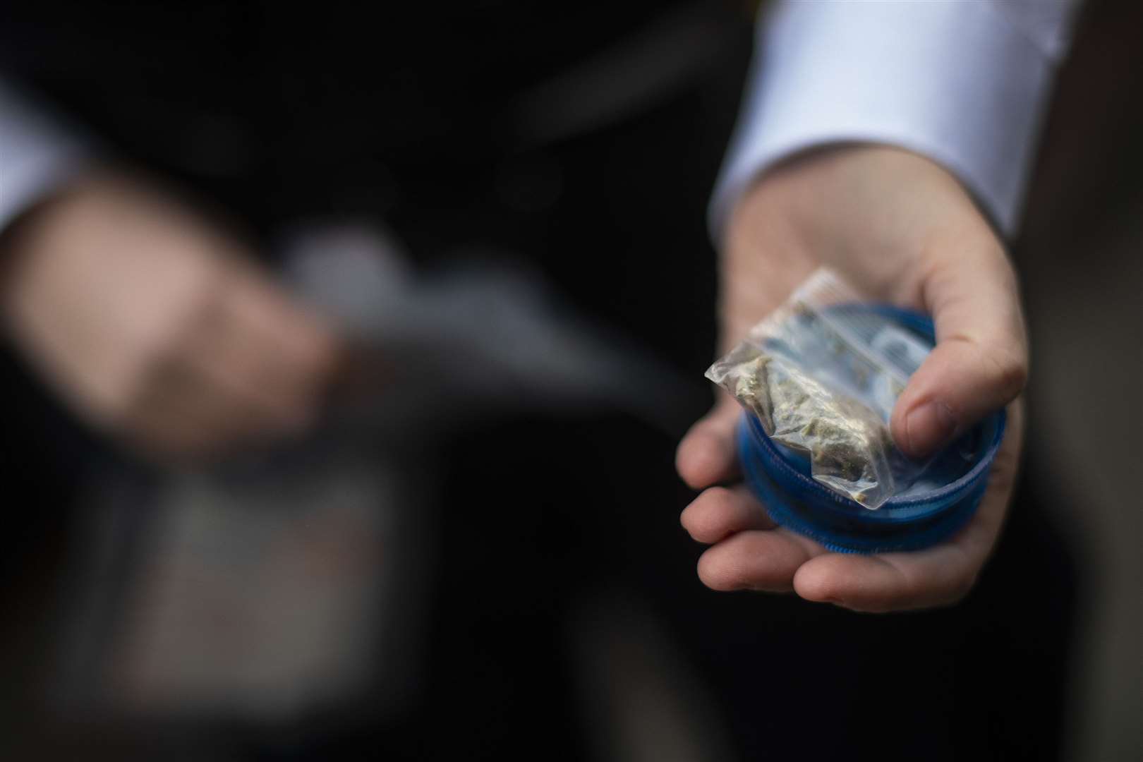 A female police officers holds a small bag of suspected cannabis found during a stop and search of a suspect (Victoria Jones/PA)