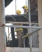 Firefighters inspect the wreckage. Picture: BARRY GOODWIN