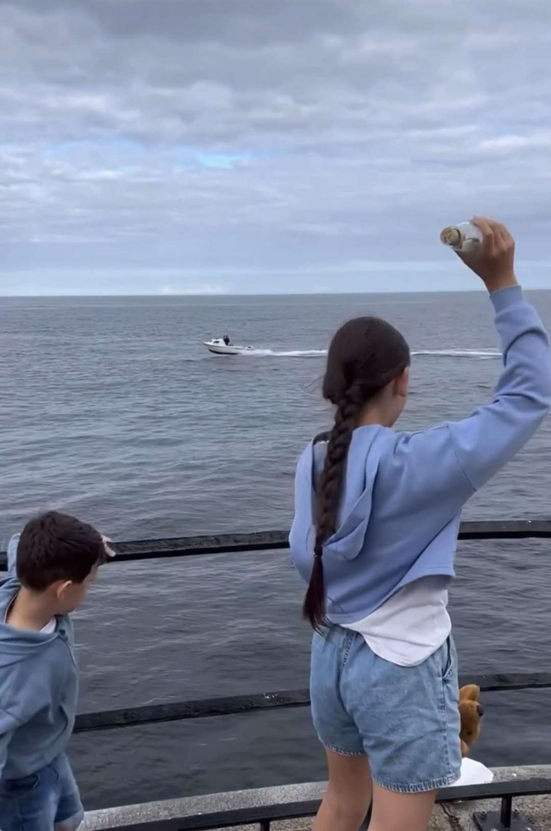 Grace getting ready to throw her bottle off the pier (Christie Bowley/PA)