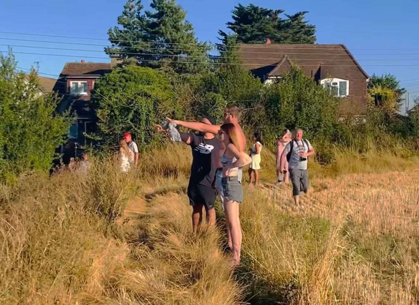 Residents watch the fire spread across a field near Burnt House Lane in Dartford. Picture: Jodie Lee Stainer