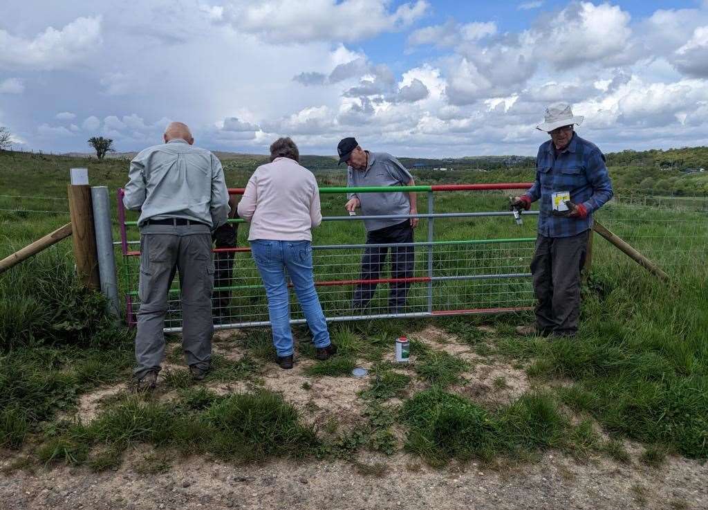 Volunteers painting gates at Nashenden Down to deter metal thieves. Image: Robert Pennington