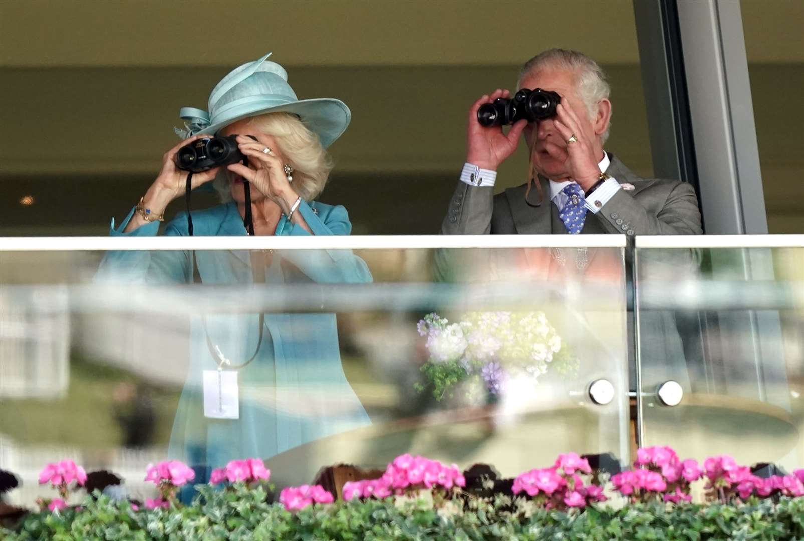 Charles and Camilla watch the King’s Stand Stakes through binoculars (Aaron Chown/PA)