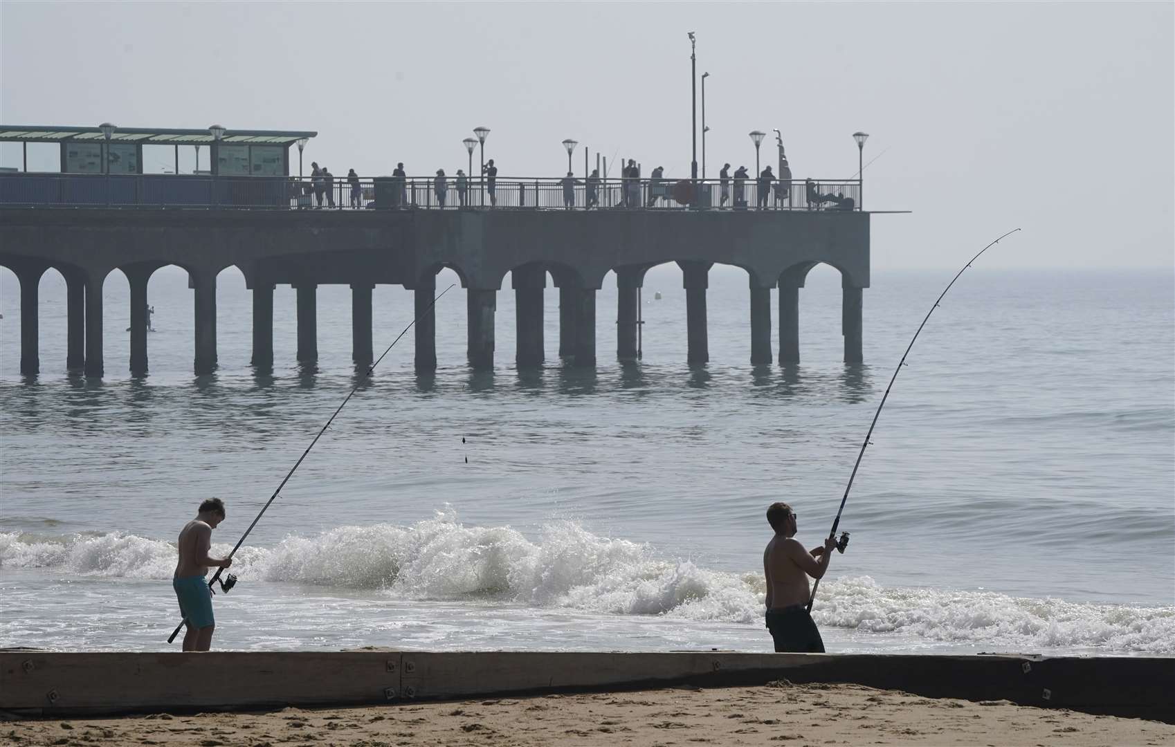 People fish in the sea next to Boscombe pier (Andrew Matthews/PA)