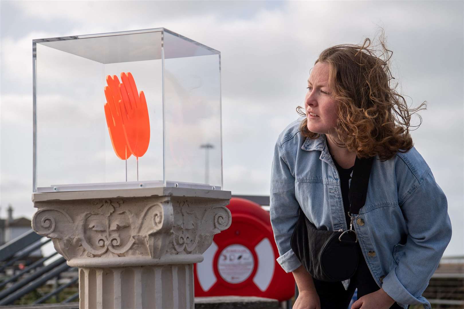 A passer-by looks at a work by Maureen Jordan on Folkestone seafront. Photo credit: Matt Crossick/PA Wire