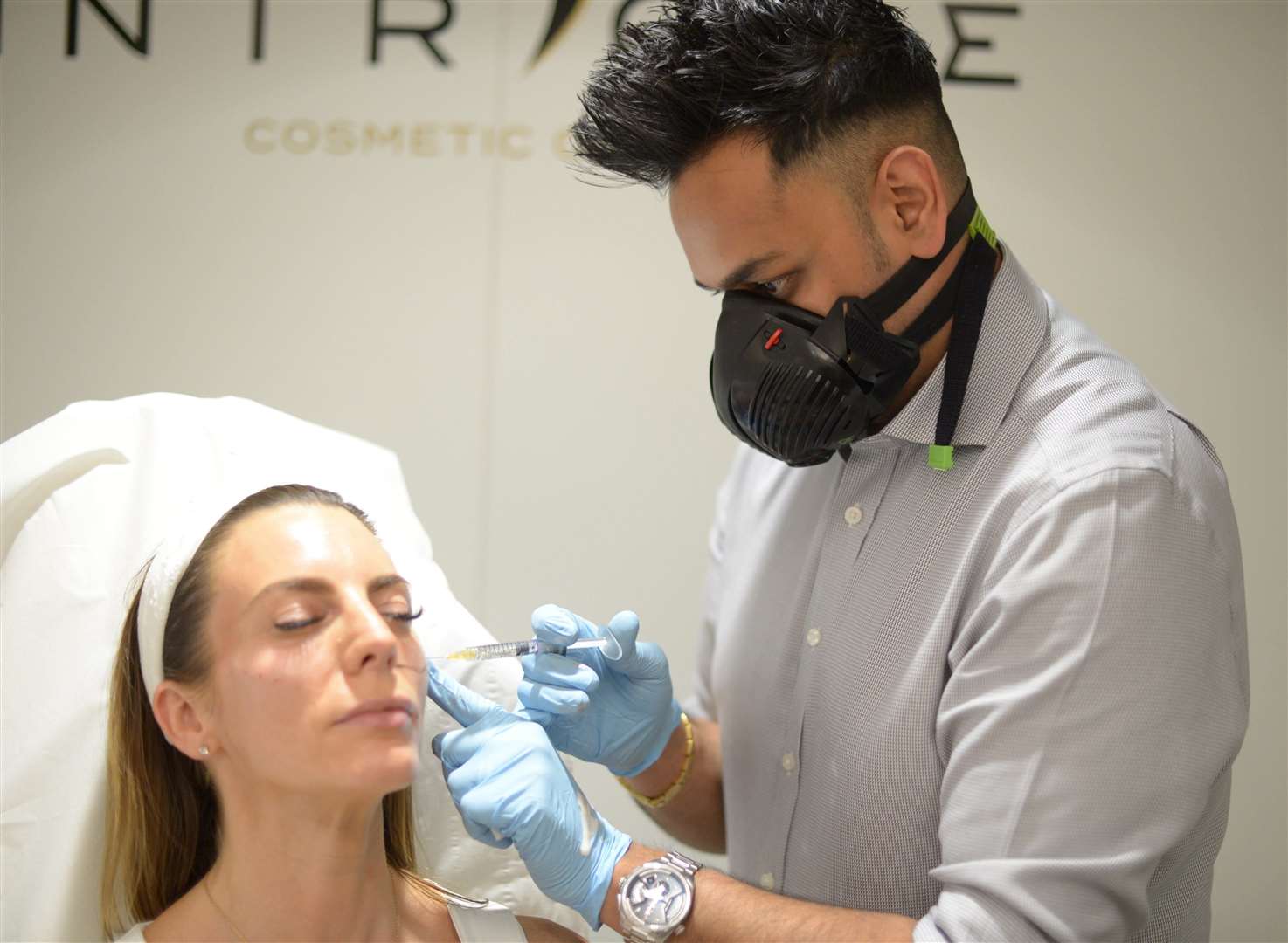 Hodgson pharmacist and Intrigue Cosmetic clinician Amish Patel performing a cheek filler procedure for a client