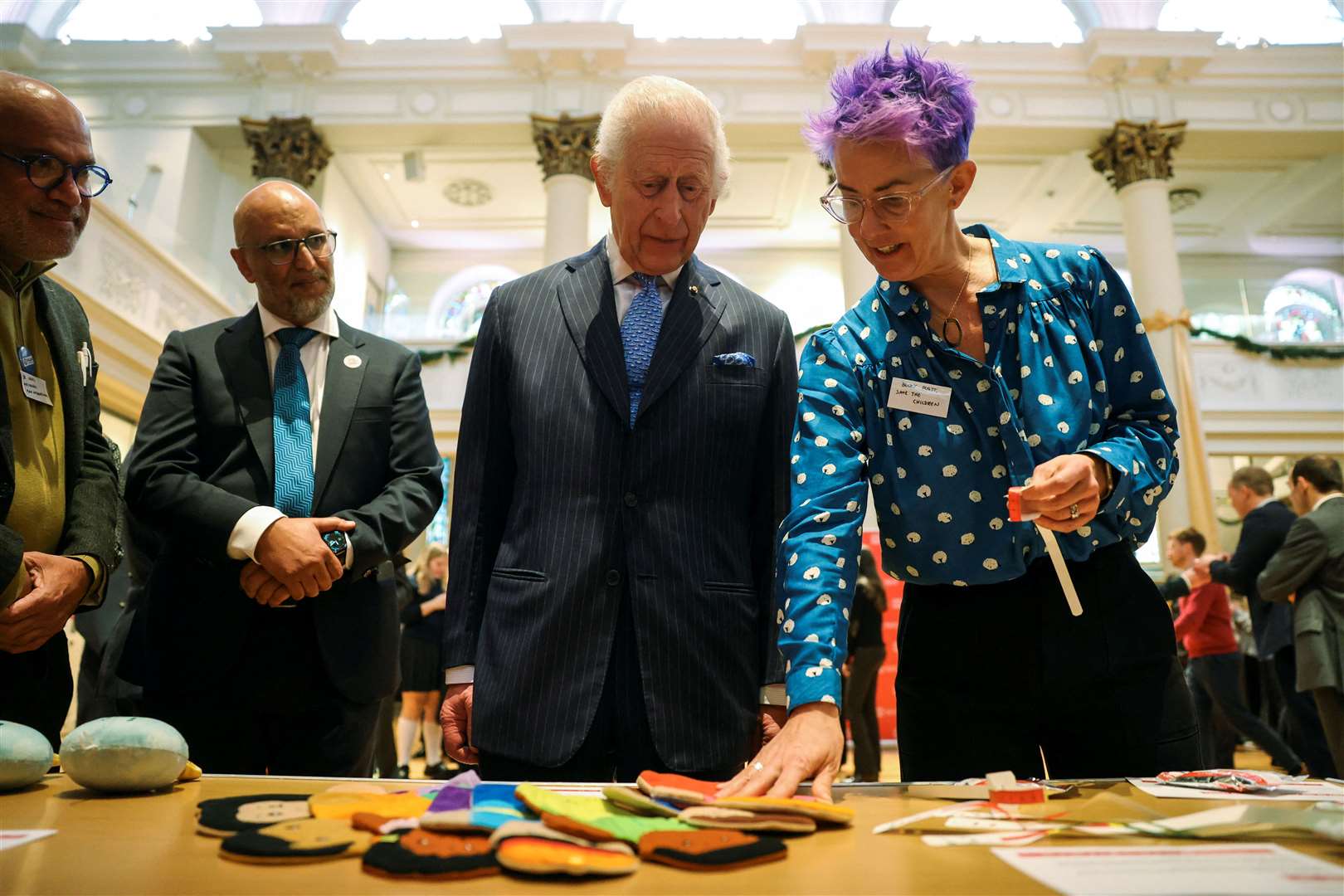 Charles is shown items used in humanitarian responses by paediatric nurse Becky Platt during a visit to St Peter’s Church in Notting Hill (Mina Kim/PA)