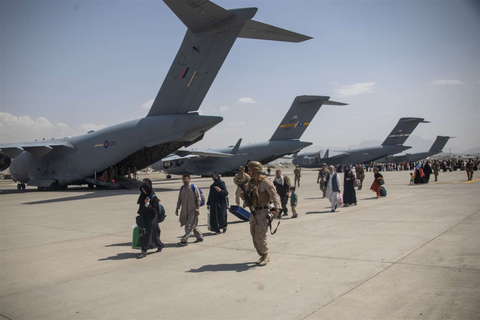 Members of the UK armed forces leading evacuees (LPhot Ben Shread/MoD/PA)