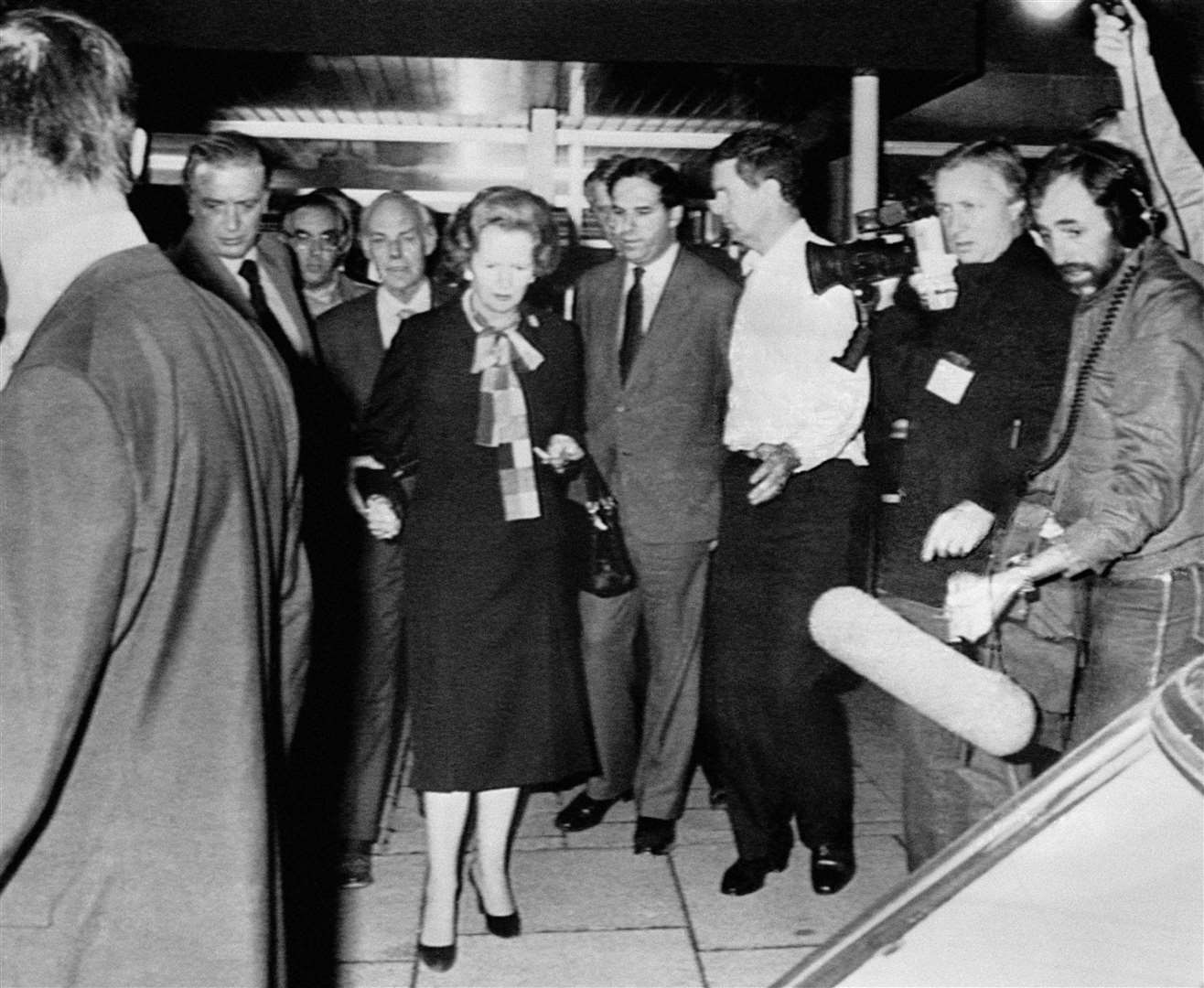 Then-prime minister Margaret Thatcher, helped by her husband Denis, leaving the Grand Hotel, Brighton following a bomb blast which ripped through the building causing severe damage and many injuries (PA)