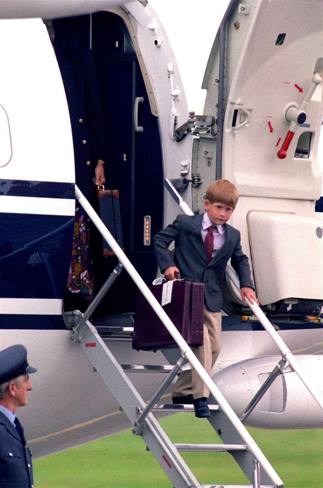 Harry, aged six, carries a briefcase down the down the steps of a plane in Scotland (Chris Bacon/PA)