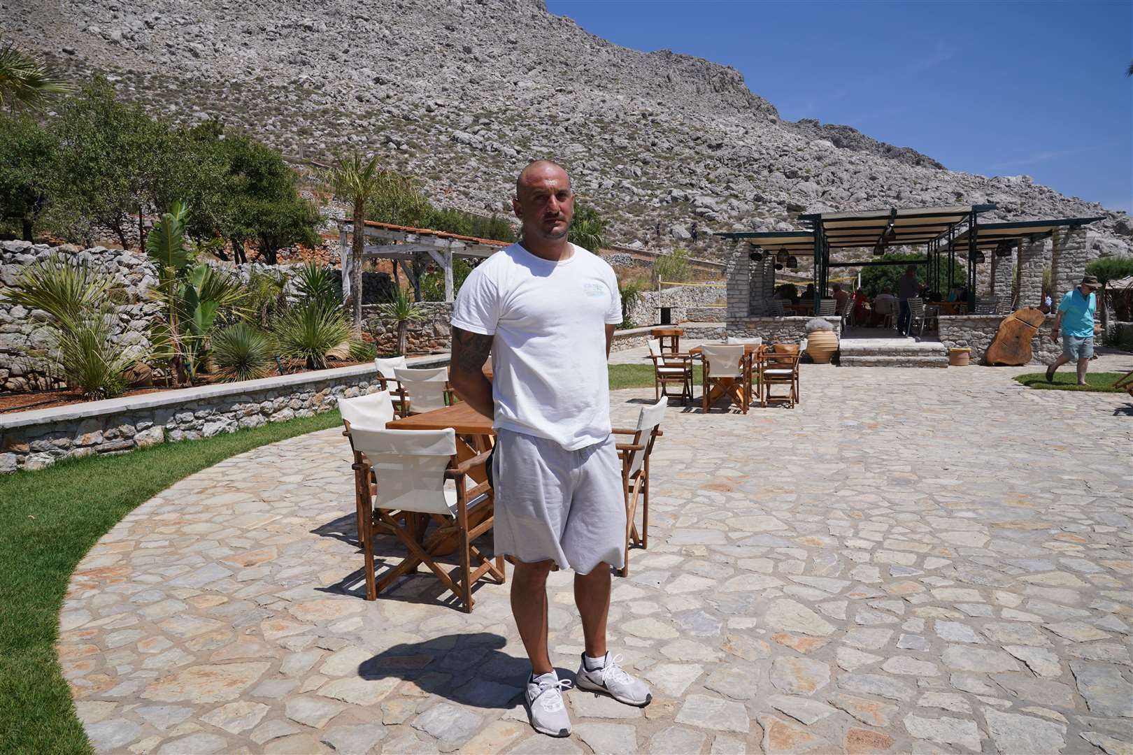 Agia Marina bar manager Ilias Tsavaris, 38, speaks to the media on Symi (Yui Mok/PA)