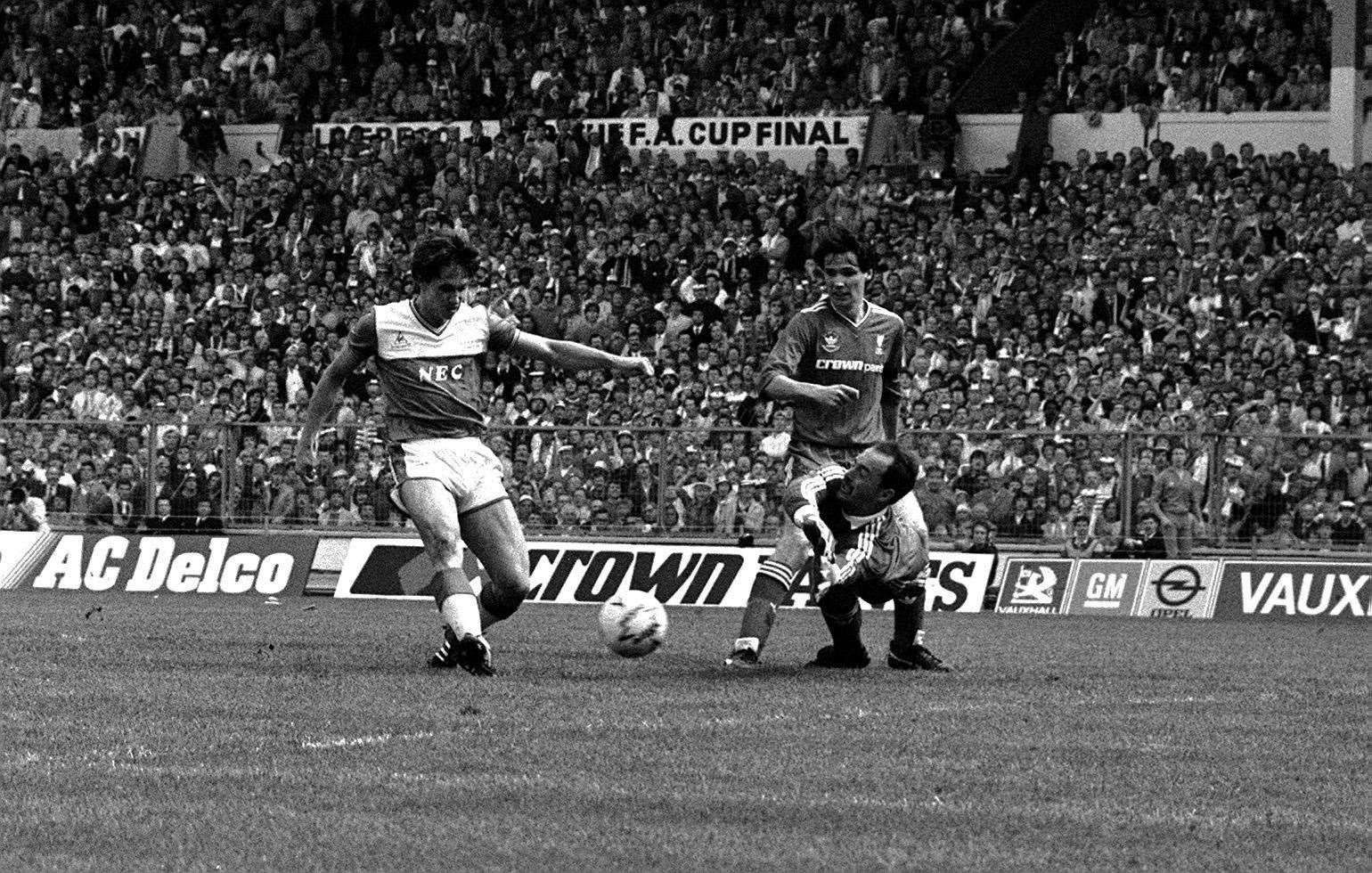 Lineker beats Liverpool goalkeeper Bruce Grobbelaar and defender Alan Hansen to score the opening goal in the 1986 FA Cup final at Wembley (PA)