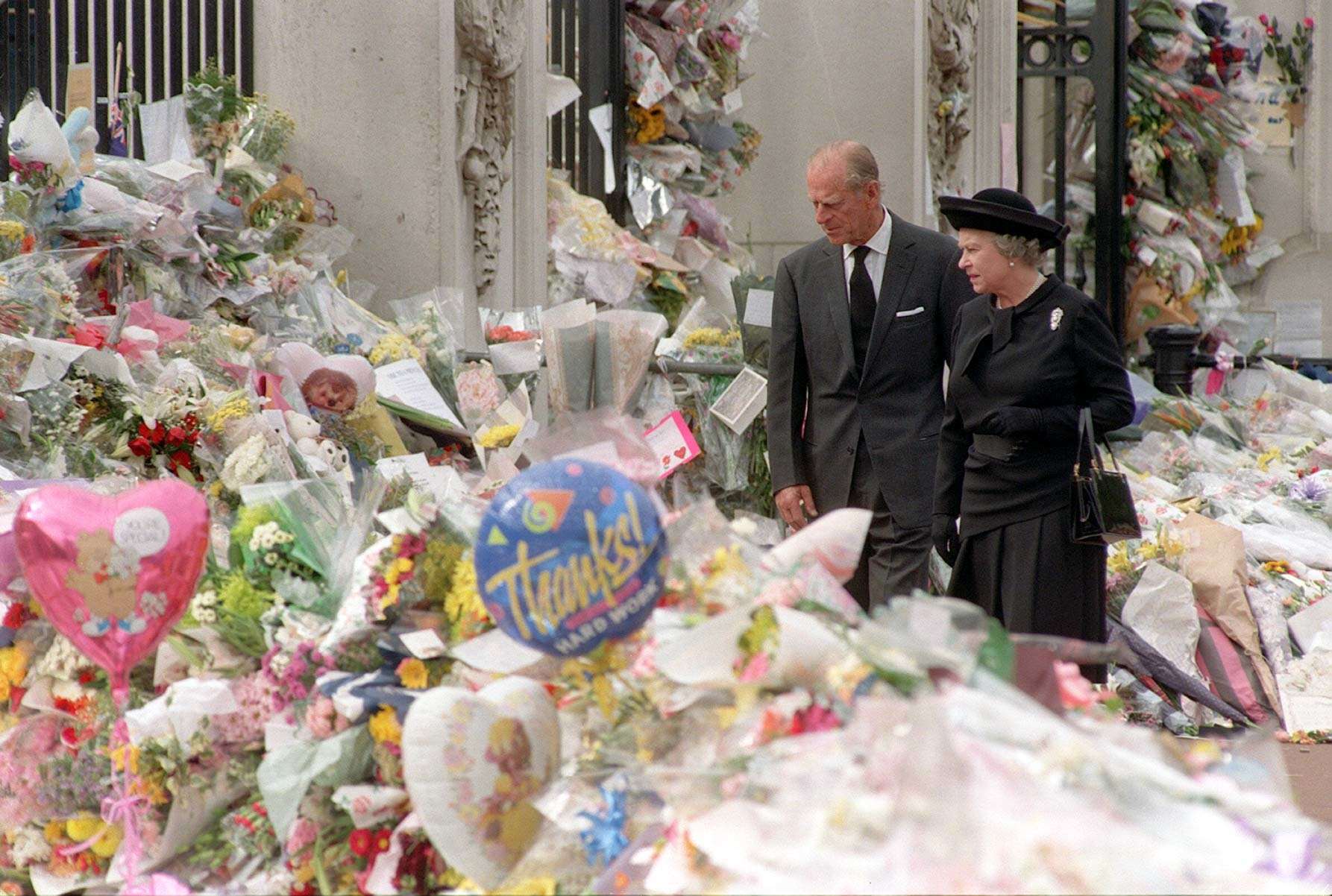 The Queen and the Duke of Edinburgh view the floral tributes to Diana, Princess of Wales, at Buckingham Palace (John Stillwell/PA)