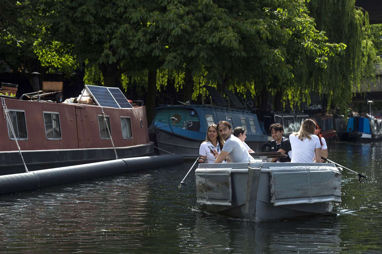 People enjoy the warm weather in a boat on the canal in Little Venice, Paddington, in London (Kirsty O’Connor/PA)