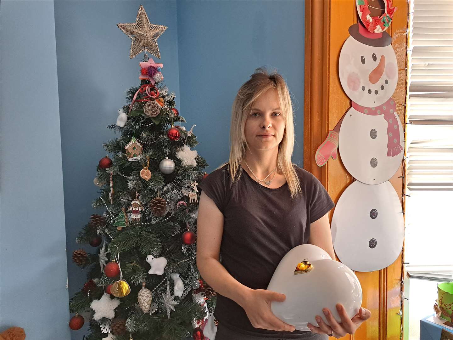 Magdalena Wisniewska, 26, holding Maya's ashes with the Christmas tree that remains up year round