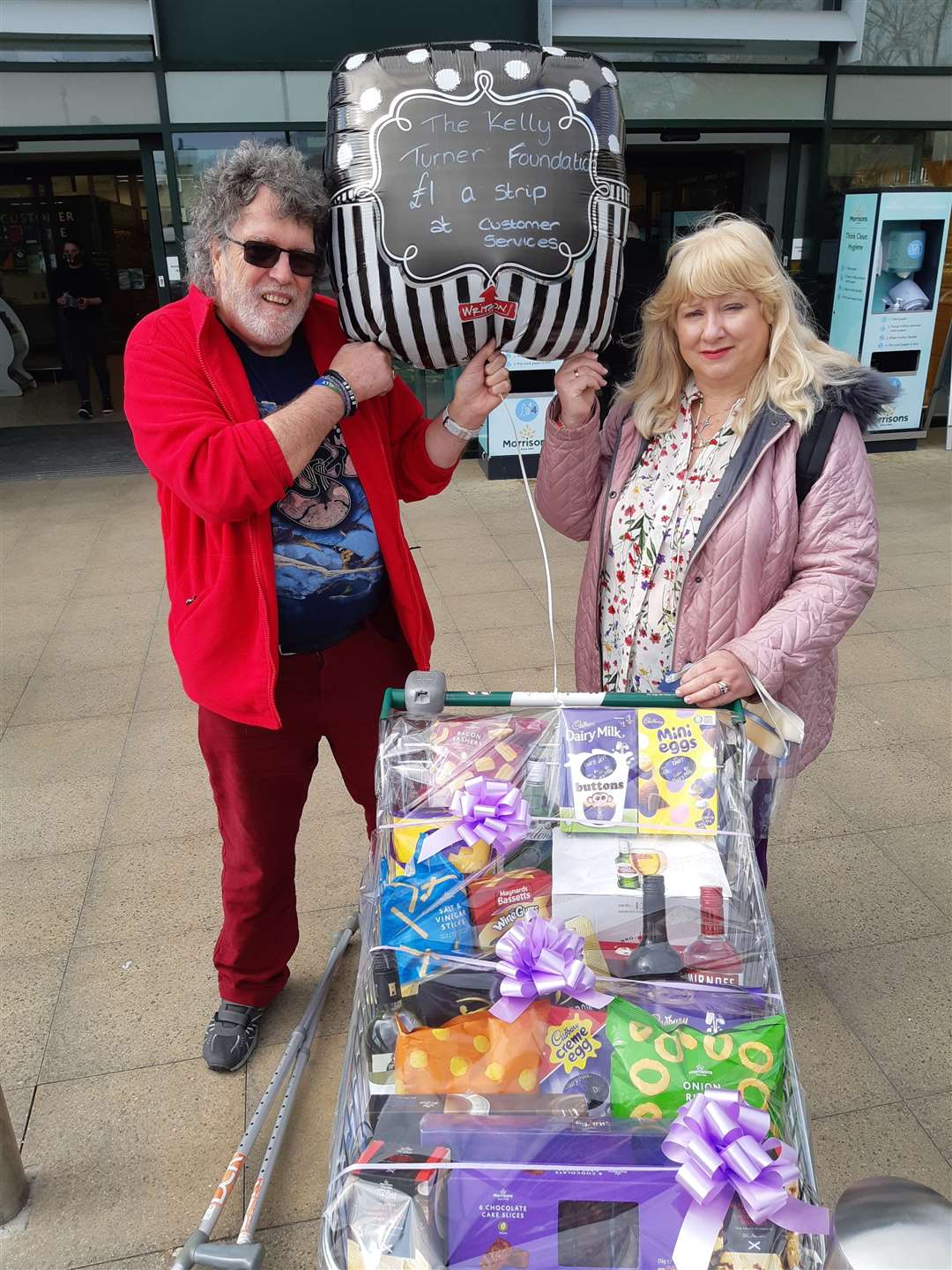 Martin and Linda Turner outside Morrisons with the trolley of goods raffled for the fundraising. Picture:Sam Lennon