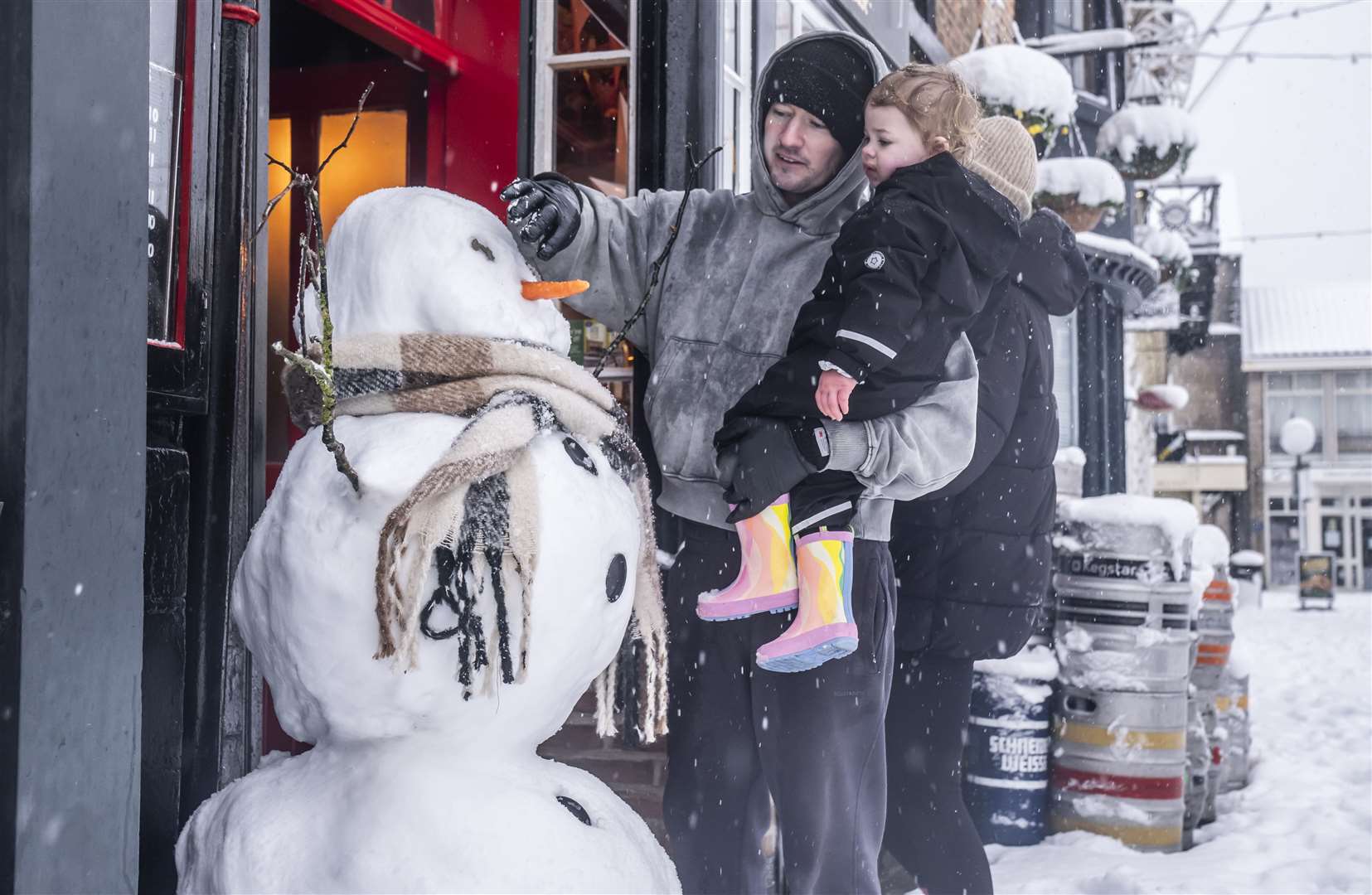 Christian Ogley with his daughter Noa make a snowman in Knaresborough, North Yorkshire (Danny Lawson/PA)