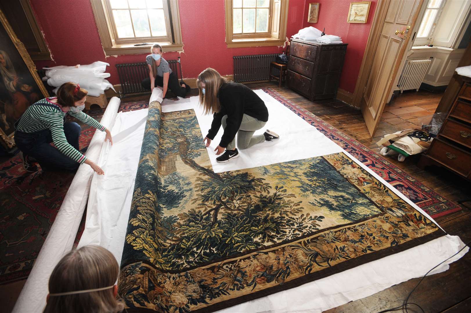 National Trust staff unroll the tapestry ready to rehang it at Dyrham Park (Barry Batchelor/National Trust/PA)