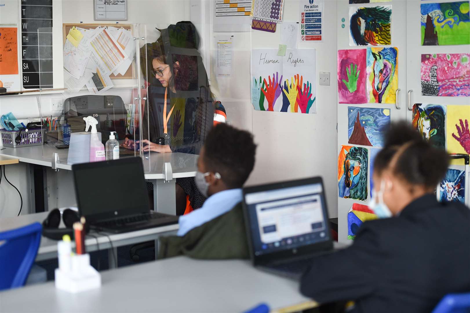 A teacher behind a screen and students in a classroom in Birmingham in the West Midlands (Jacob King/PA)