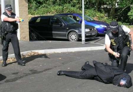 Kent Police officers demonstrate the taser gun.