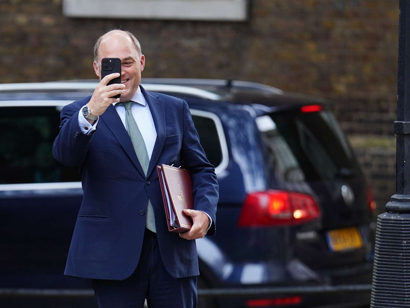 Defence Secretary Ben Wallace, takes a picture of the media with his phone as he arrives in Downing Street for what could have been his last Cabinet meeting (James Manning/PA)