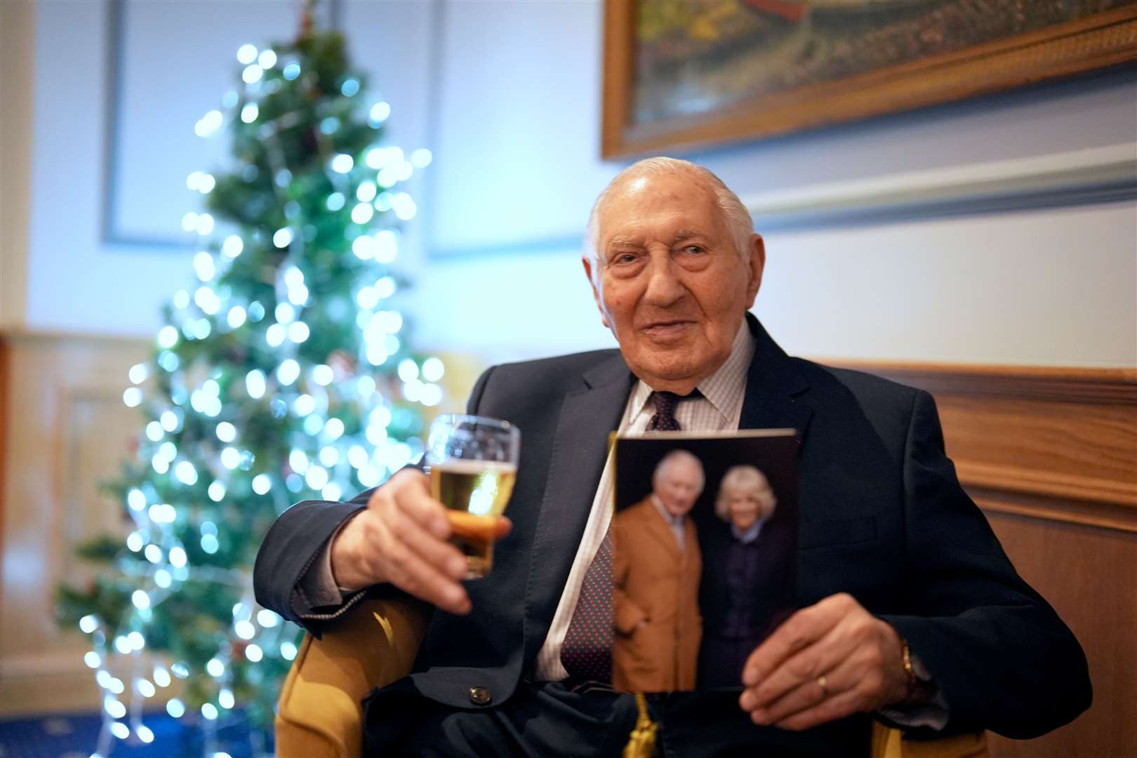 Normandy veteran Mervyn Kersh enjoys a drink as he reads his birthday card from the King during a surprise party for his 100th birthday at the Union Jack Club in London (Jordan Pettitt/PA)