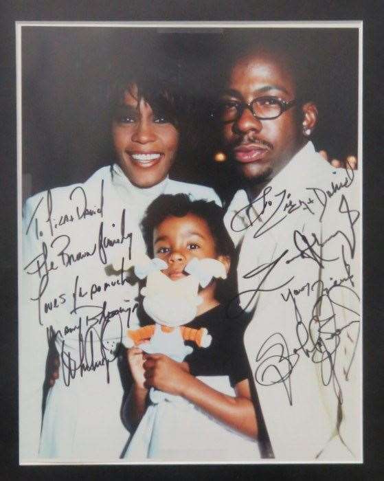 Signed photograph by Whitney Houston with husband Bobby Brown and daughter Bobbi Kristina Brown (David Gest estate/PA)