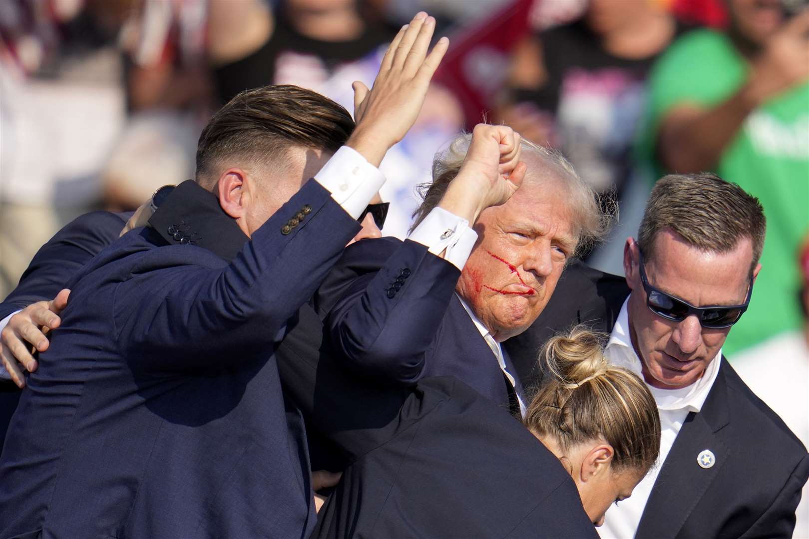 Donald Trump is helped off the stage by US Secret Service agents (Gene J. Puskar/AP)