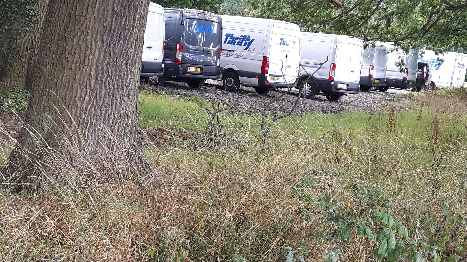 Vans parked on the spillover car park behind a rugby pitch (15443144)