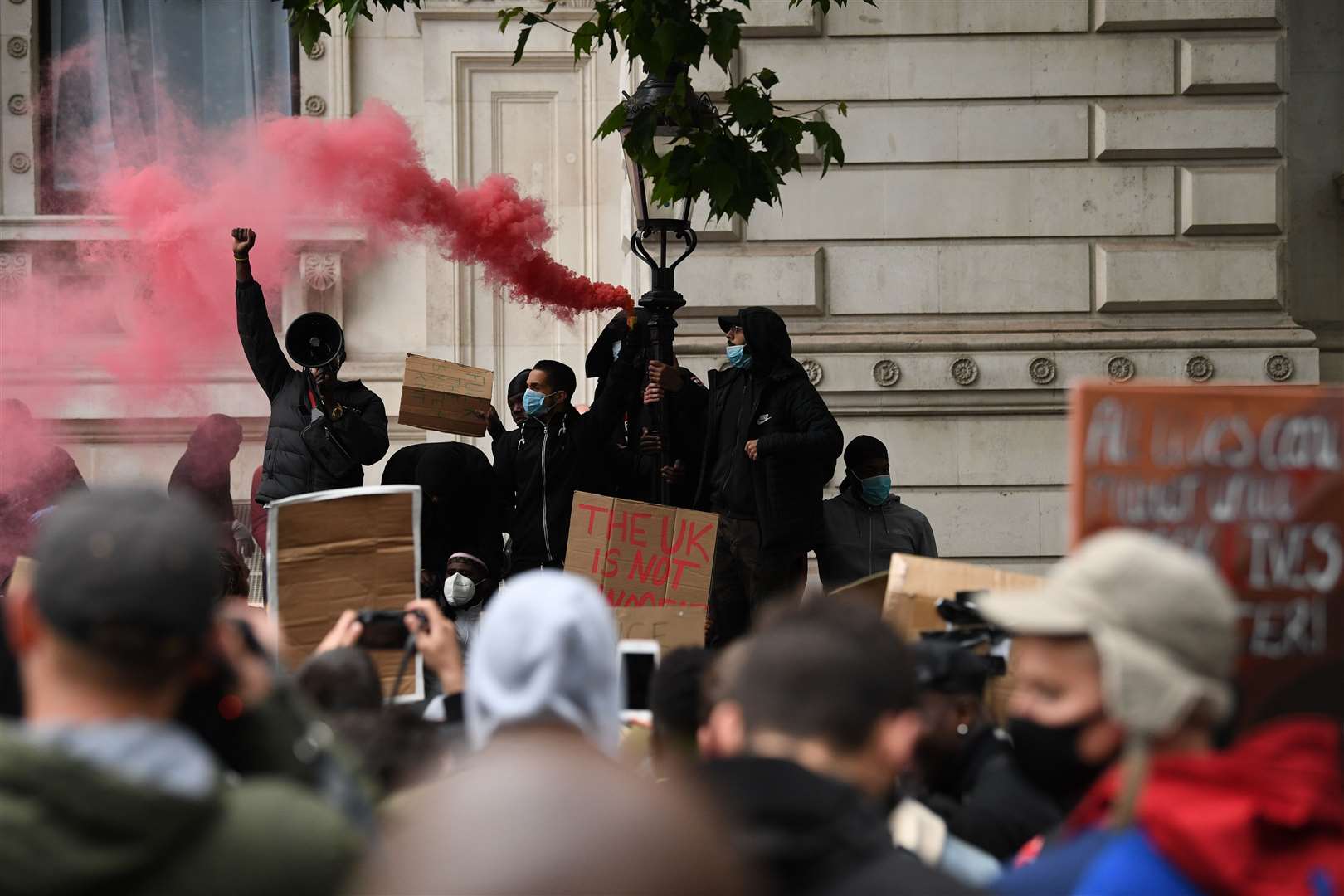 People let off red smoke flares at the protest on Saturday (Stefan Rousseau/PA)