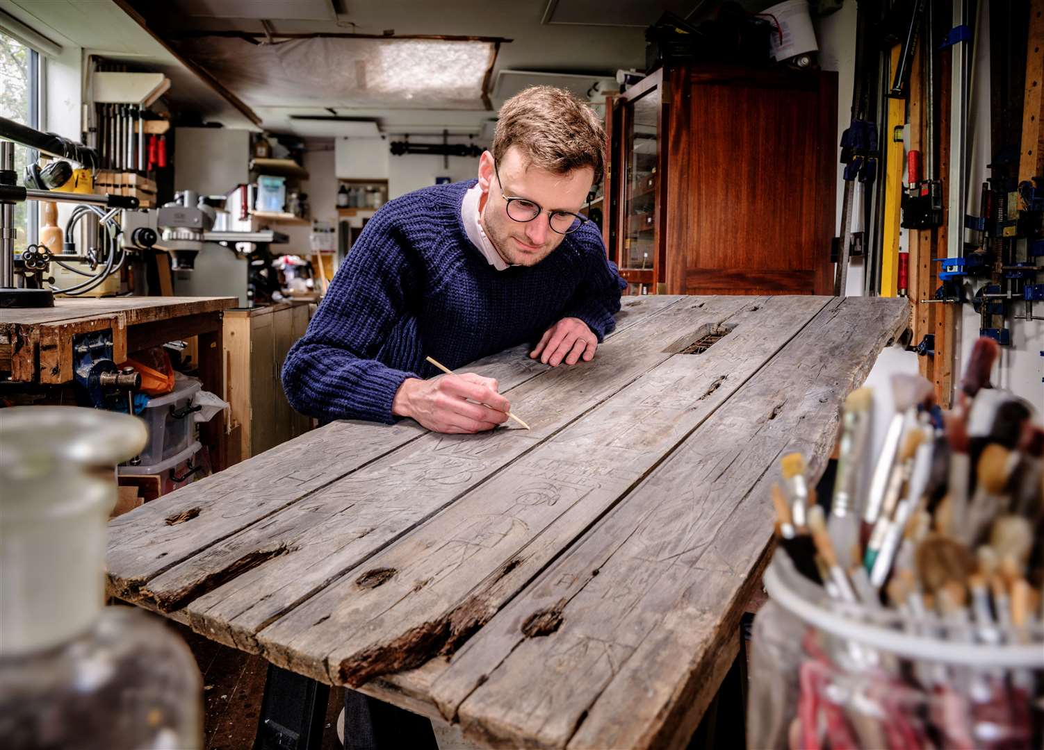 A historian examines more than 50 pieces of graffiti on the door from the 1790s. Picture: English Heritage