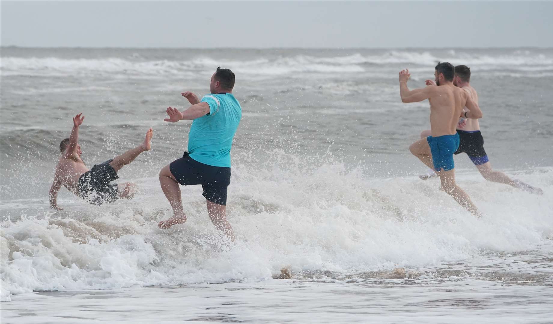 There was little hesitation shown by those running into the icy North Sea (Owen Humphreys/PA)