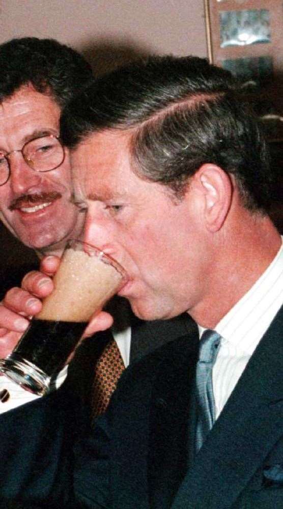 Charles sips a glass of Guinness, watched by Irish deputy prime minister Dick Spring during his 1995 visit (Martin Keene/PA)