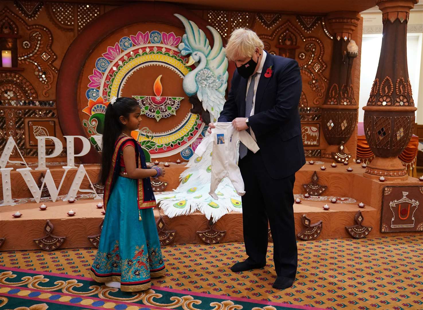 Boris Johnson is given a gift of a babygro (Yui Mok/PA)