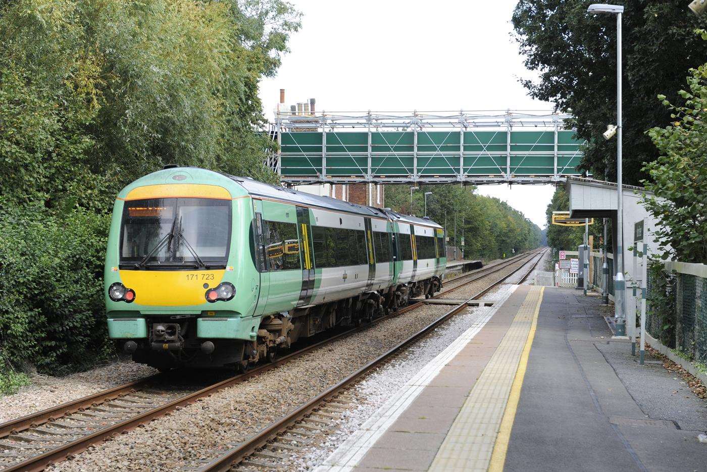 A train goes under the new footbridge at Hamstreet