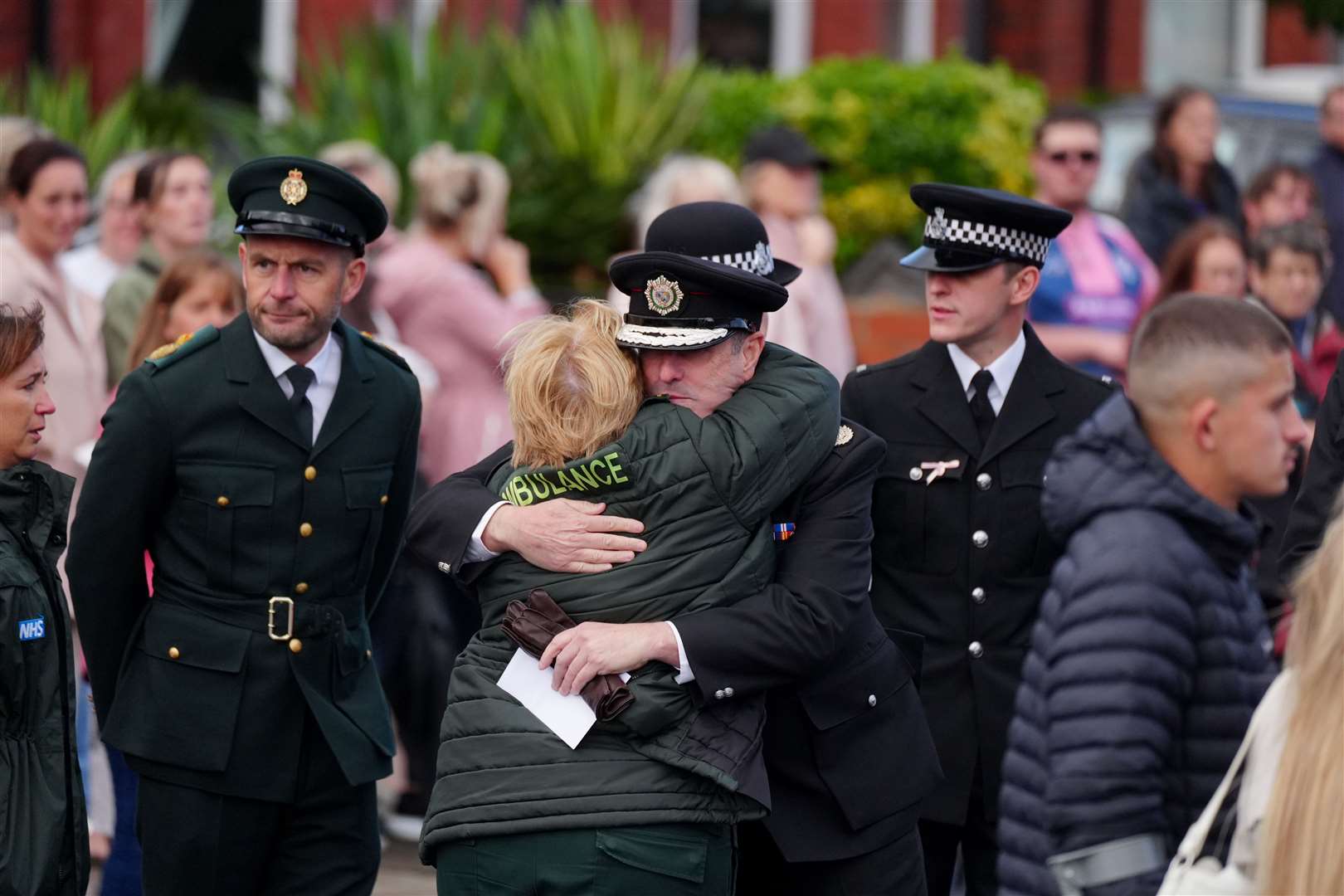 Two members of the emergency services embrace while waiting for the funeral of Southport stabbing victim Elsie Dot Stancombe (Peter Byrne/PA)