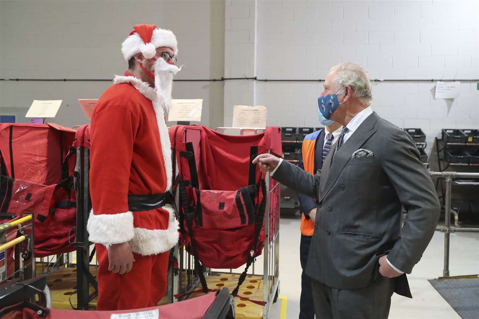 Charles speaks to postal worker Tim Lafford dressed in a Father Christmas outfit (Geoff Caddick/PA)