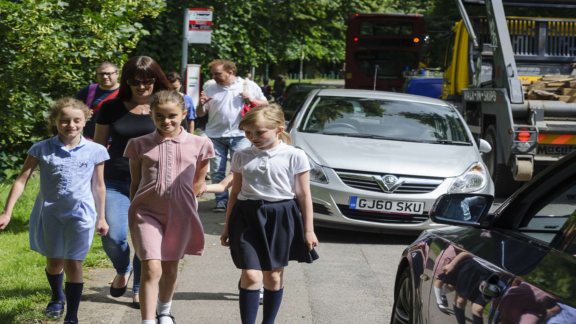 Livia Wright, 10, Lillia, DeBuc, 10, and Ellie Meagan, 10, walking down from the primary school past cars parked on the pavement.