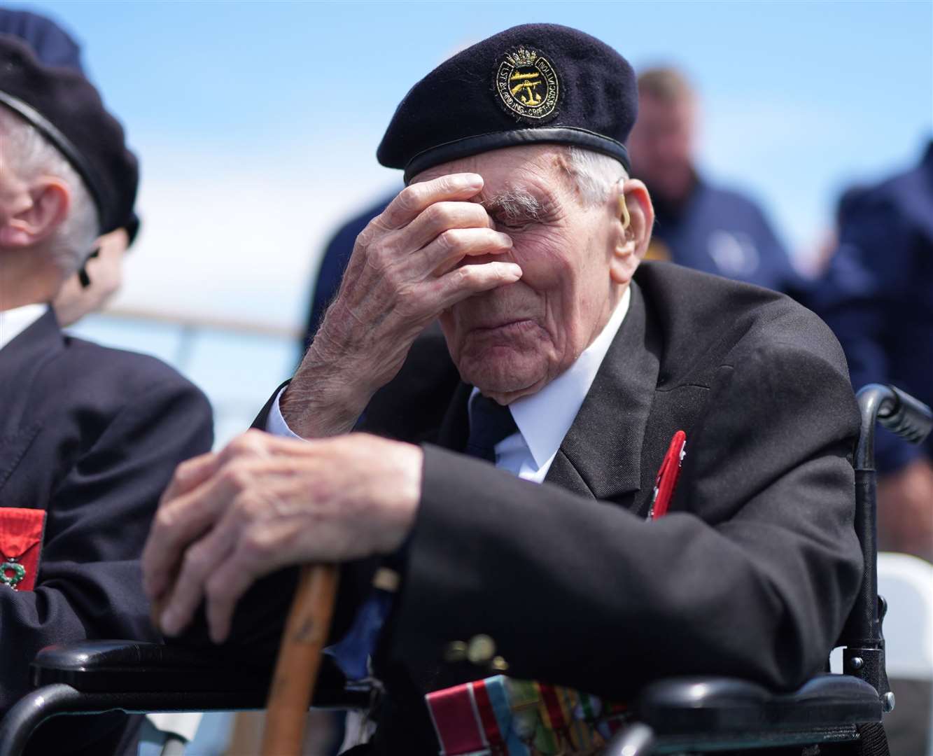 D-Day veteran John Dennett, 99, from Liverpool, covers his eyes during a wreath-laying service just off the French coastline (Jordan Pettitt/PA)